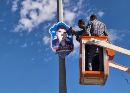 نصب تابلوها مزین به نام و تصاویر شهدا در بلوار امام رضا (ع) در استهبان